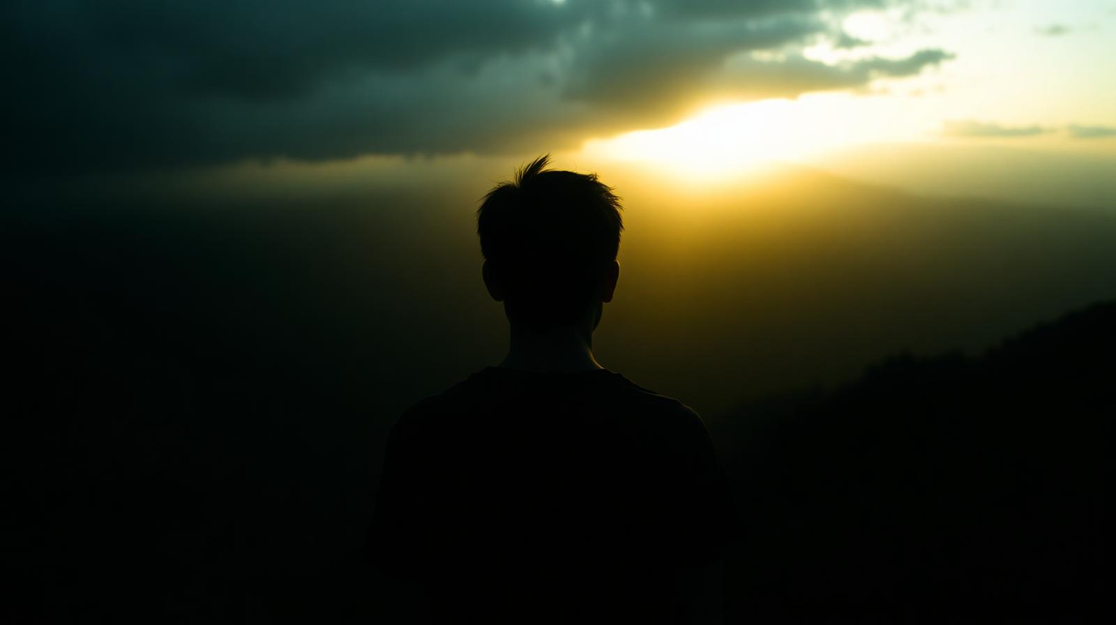 Young person at sunrise looking toward an open horizon